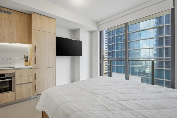 a bedroom with a bed and a flat screen tv
