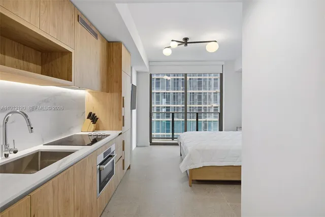 a spacious bedroom with a bed and a flat screen tv