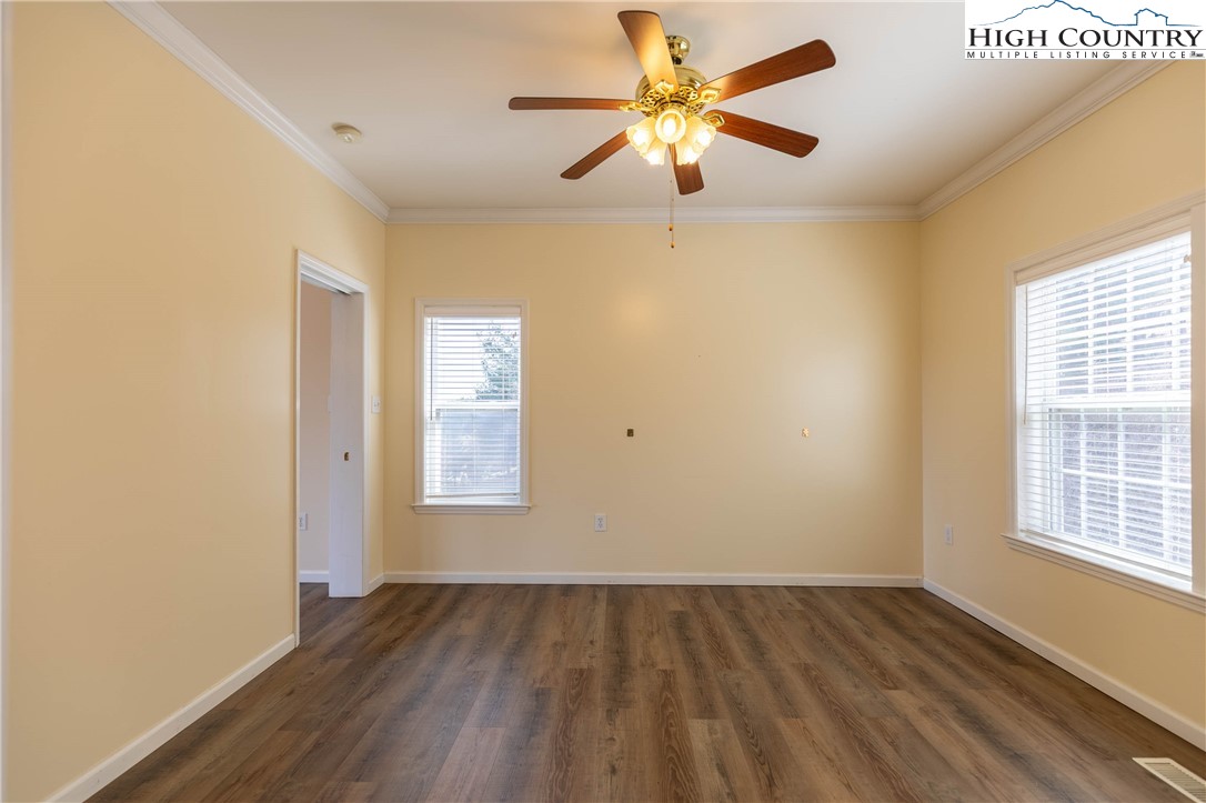 449 Meadow Ridge Drive Jefferson, NC 28640 - Photo 16 of 37 an empty room with wooden floor chandelier fan and windows