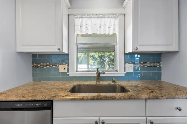a kitchen with stainless steel appliances granite countertop a refrigerator sink and stove