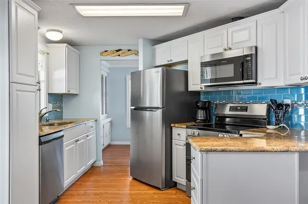 a kitchen with stainless steel appliances granite countertop a refrigerator sink and stove