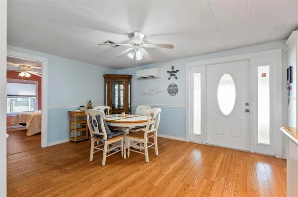 a kitchen with stainless steel appliances kitchen island granite countertop a refrigerator a stove top oven a sink dishwasher and white cabinets with wooden floor