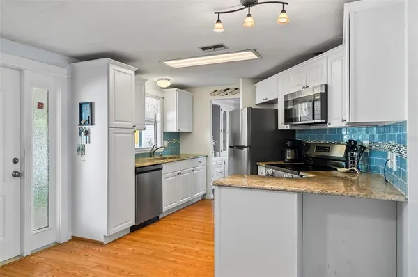 a kitchen with granite countertop a sink window and cabinets