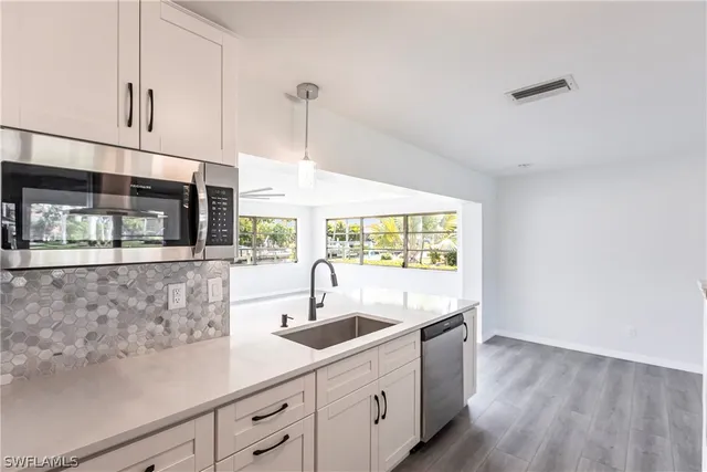 a kitchen with stainless steel appliances a sink and a large window