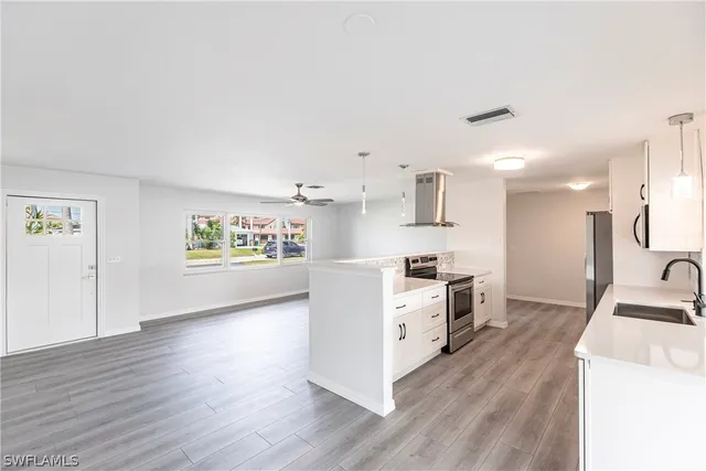 a kitchen with cabinets wooden floor and a fireplace