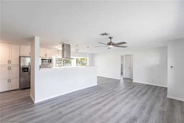 a view of a kitchen with wooden floor and a ceiling fan