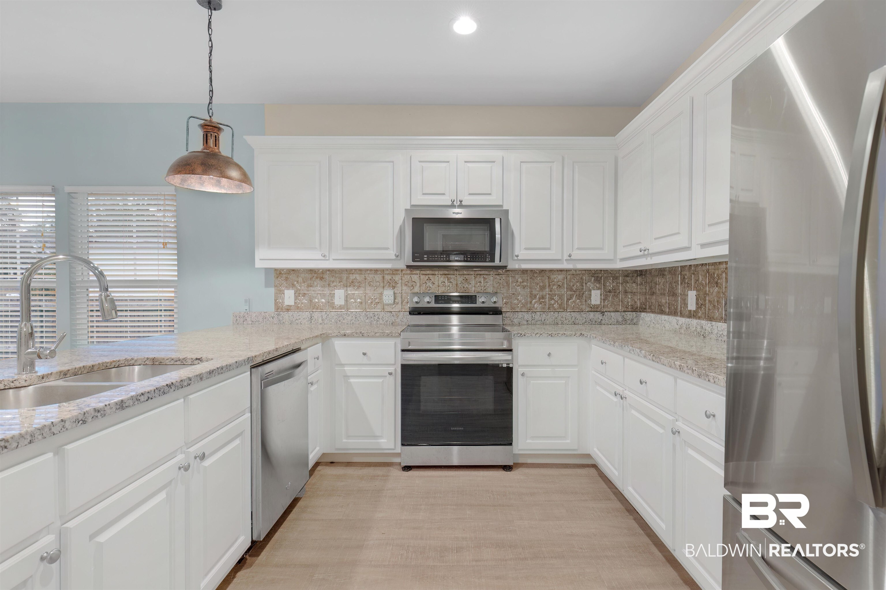 5625 Georgia Street Orange Beach, AL 36561 - Photo 11 of 30 Kitchen featuring stainless steel appliances, white cabinets, sink, and pendant lighting