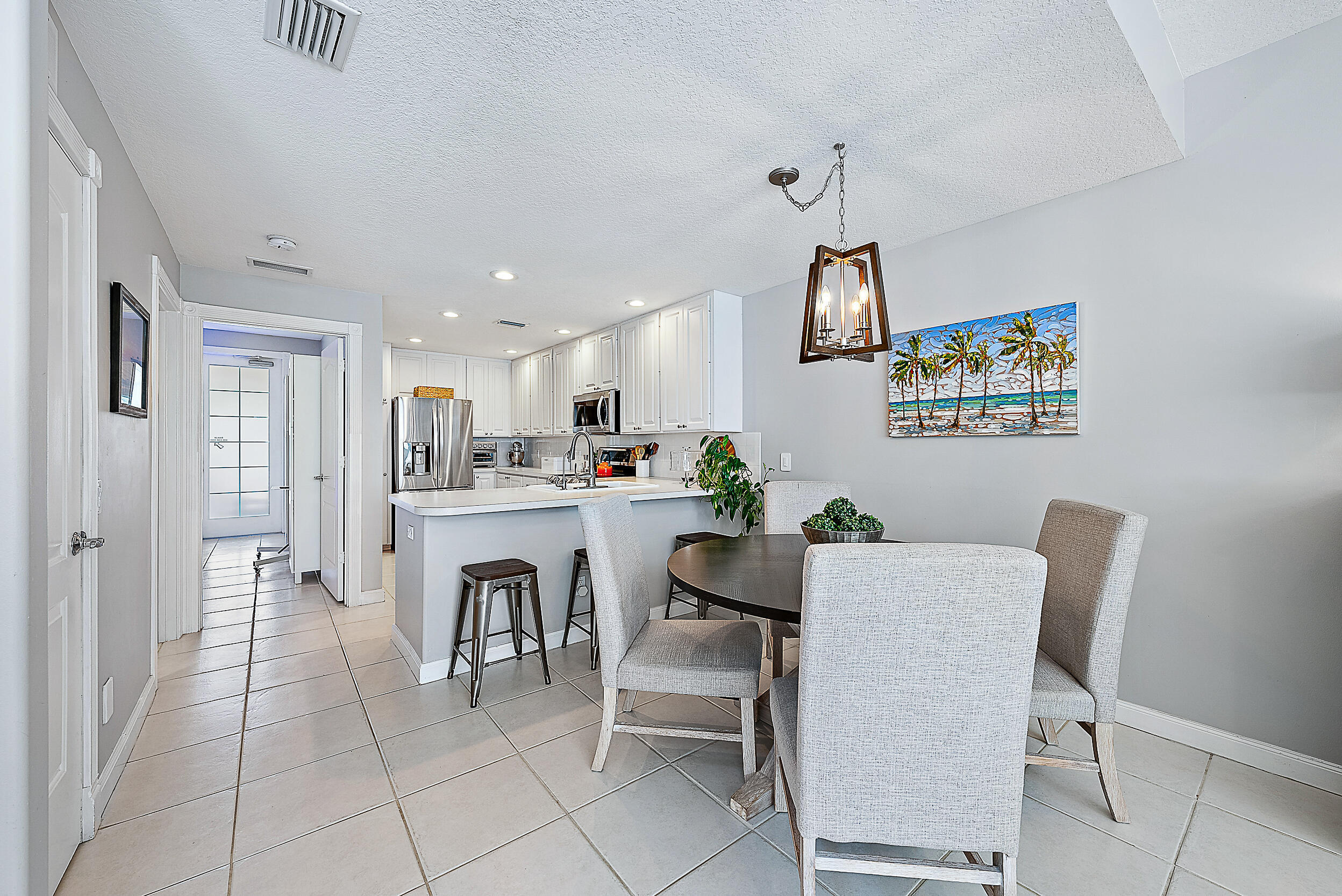 107 Rivinia Drive Jupiter, FL 33458 - Photo 7 of 28 a view of kitchen with dining area refrigerator and wooden floor