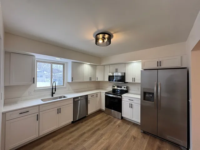 a kitchen with a sink cabinets and stainless steel appliances