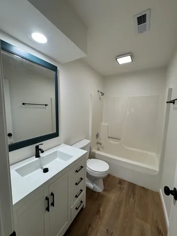 a bathroom with a double vanity sink toilet mirror and bathtub