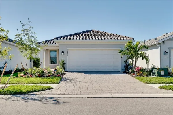 a front view of a house with a yard and potted plants