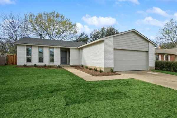 front view of a house with a yard and trees
