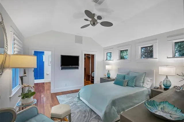 a bedroom with a bed a couch and a chandelier