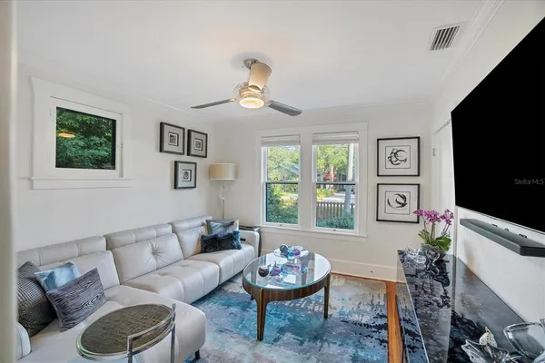 a living room with furniture a window and a flat screen tv