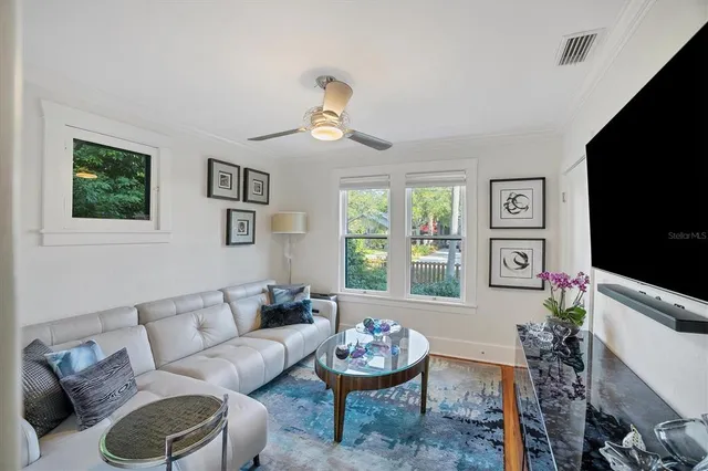 a living room with furniture a window and a flat screen tv