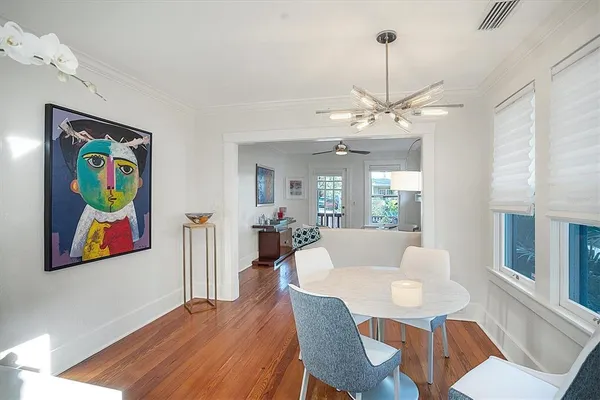 a view of a dining room with furniture a chandelier and wooden floor