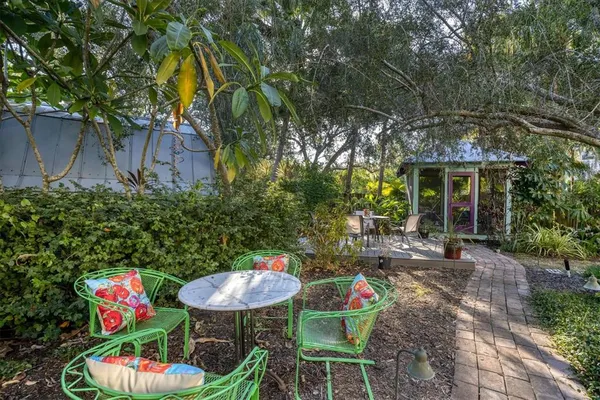 a backyard of a house with fountain table and chairs