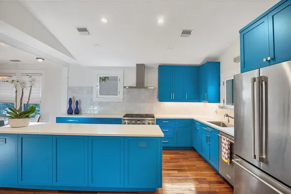 a kitchen with kitchen island granite countertop wooden cabinets a refrigerator and a sink