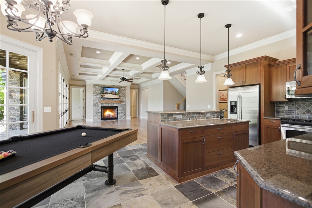 130 River Ridge Road Sunset, SC 29685 - Photo 27 of 47 An inviting open-concept area combines a chef’s kitchen and entertainment space, featuring a cozy fireplace and convenient outdoor access.