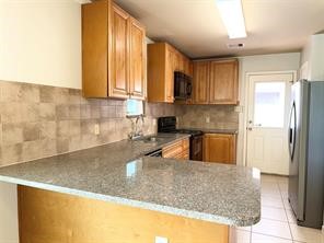 10064 Emnora Lane Houston, TX 77080 - Photo 14 of 31 a kitchen with granite countertop a sink a stove and a refrigerator