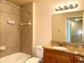 a bathroom with a granite countertop toilet a sink and shower