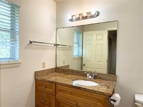 10064 Emnora Lane Houston, TX 77080 - Photo 21 of 31 a bathroom with a granite countertop sink and a mirror