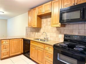 10064 Emnora Lane Houston, TX 77080 - Photo 27 of 31 a kitchen with granite countertop a stove sink and microwave