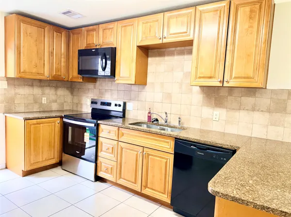 a kitchen with stainless steel appliances granite countertop a sink and a stove
