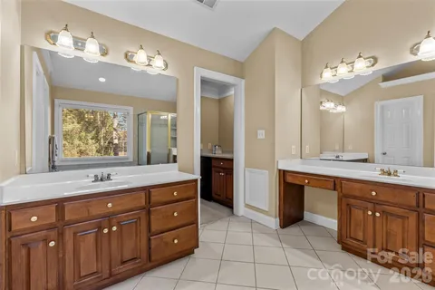 a spacious bathroom with a granite countertop sink a large mirror and a bathtub