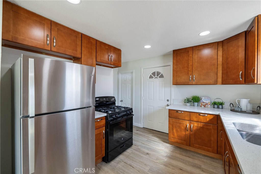 3751 McKenzie Street Riverside, CA 92503 - Photo 21 of 68 a kitchen with stainless steel appliances granite countertop a refrigerator a sink dishwasher a stove with wooden floor