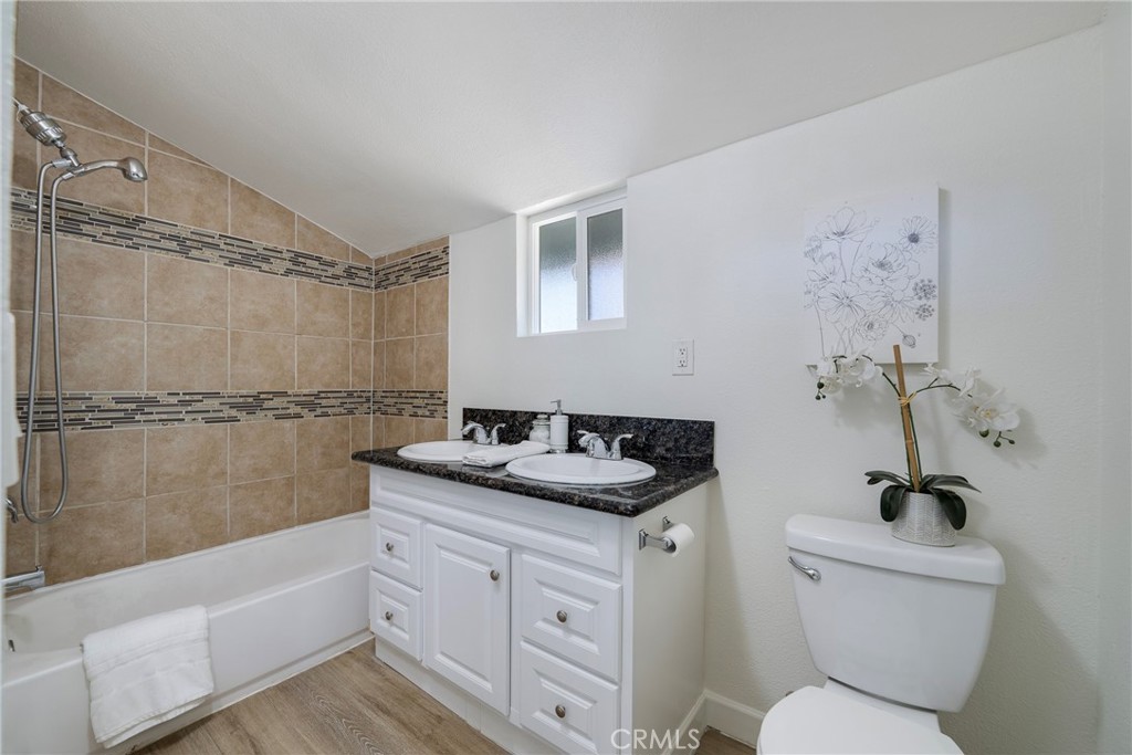 3751 McKenzie Street Riverside, CA 92503 - Photo 30 of 68 a bathroom with a granite countertop sink a toilet and shower