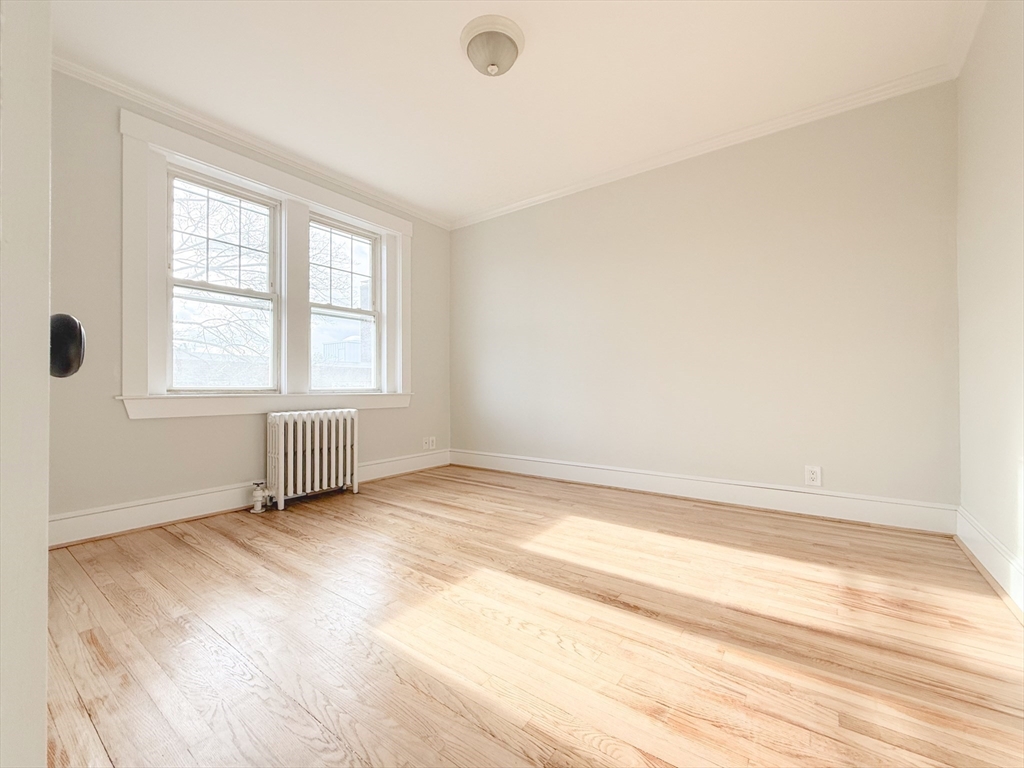 56 Selkirk Road, Unit 8 Boston, MA 02135 - Photo 8 of 8 an empty room with wooden floor and windows