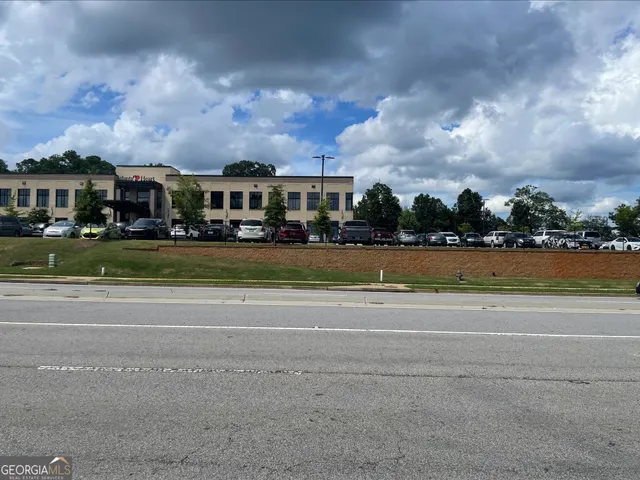 a view of a big house with a big yard and large trees