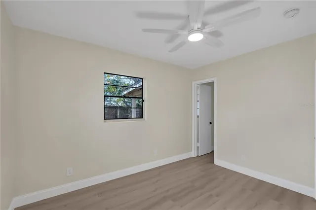 an empty room with windows and fan