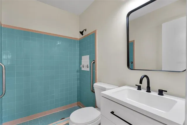 a bathroom with a sink a toilet and shower