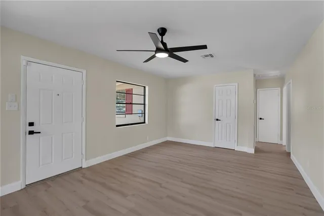 a view of empty room with wooden floor