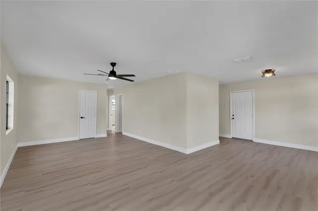 a view of an empty room with wooden floor