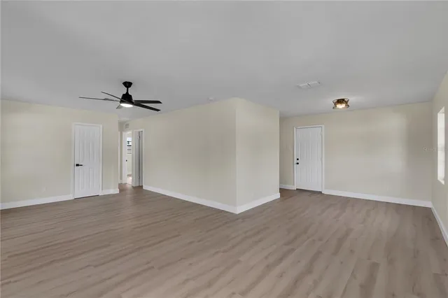 a view of an empty room with wooden floor