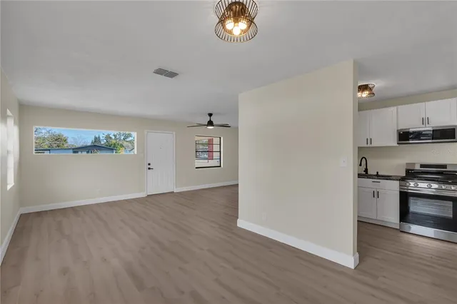 a view of a kitchen with a sink a refrigerator and window