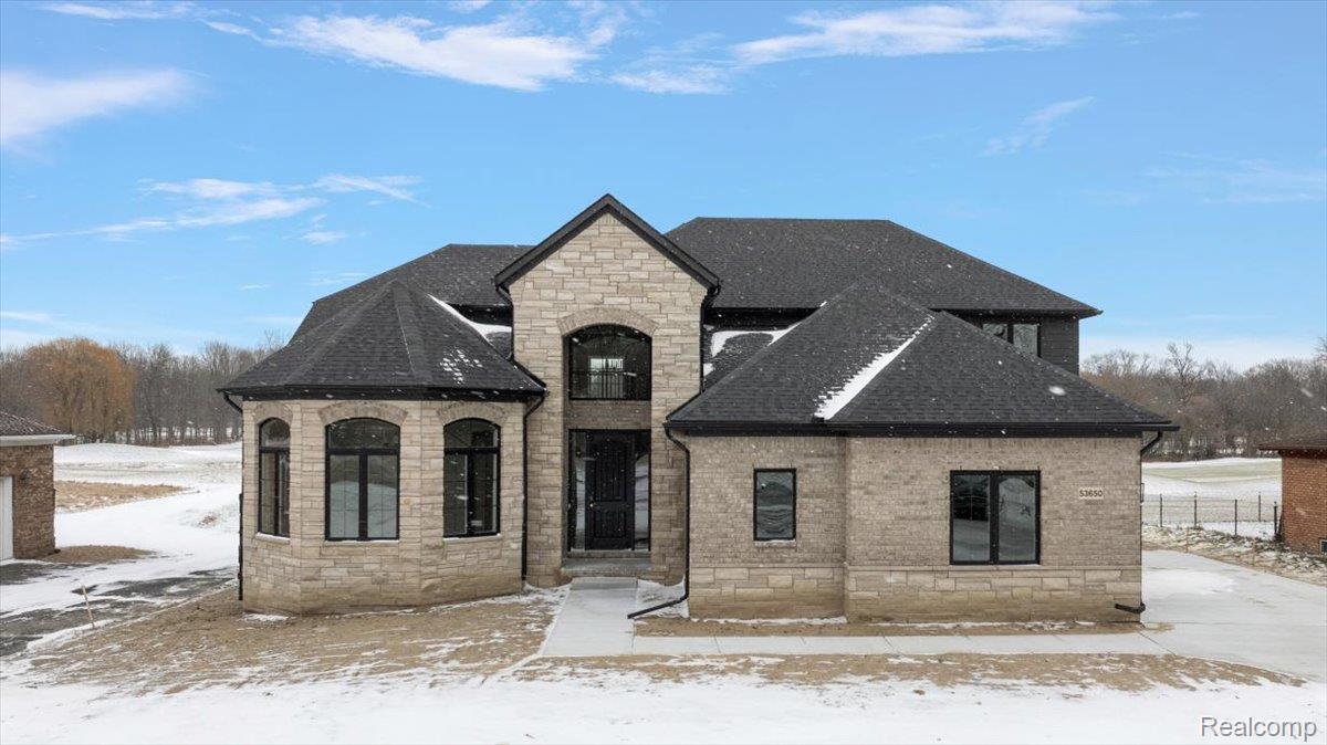 53650 Romeo Plank Road Macomb, MI 48042 - Photo 2 of 64 French country style house featuring stone siding, roof with shingles, and brick siding