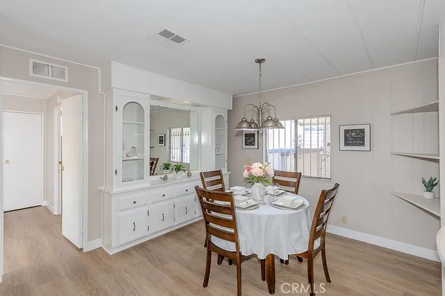 a dining room with furniture a chandelier and wooden floor