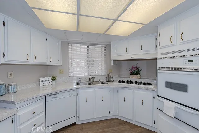 a kitchen with cabinets appliances a sink and a window