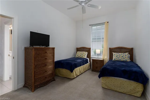 a bedroom with two beds and a flat screen tv