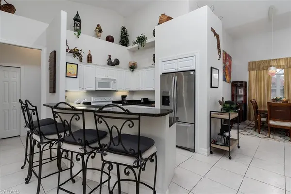a kitchen with stainless steel appliances granite countertop a table and chairs in it
