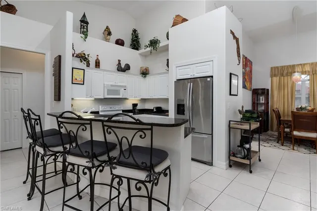 a kitchen with stainless steel appliances granite countertop a table and chairs in it