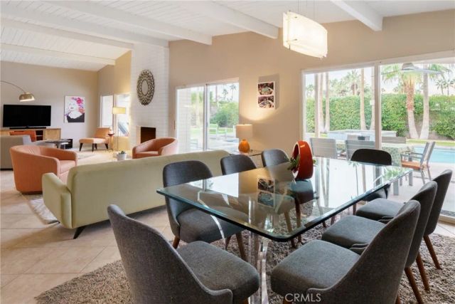 a living room with furniture a large window and a flat screen tv
