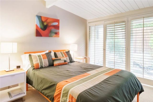 a bedroom with a bed and a painting on the wall