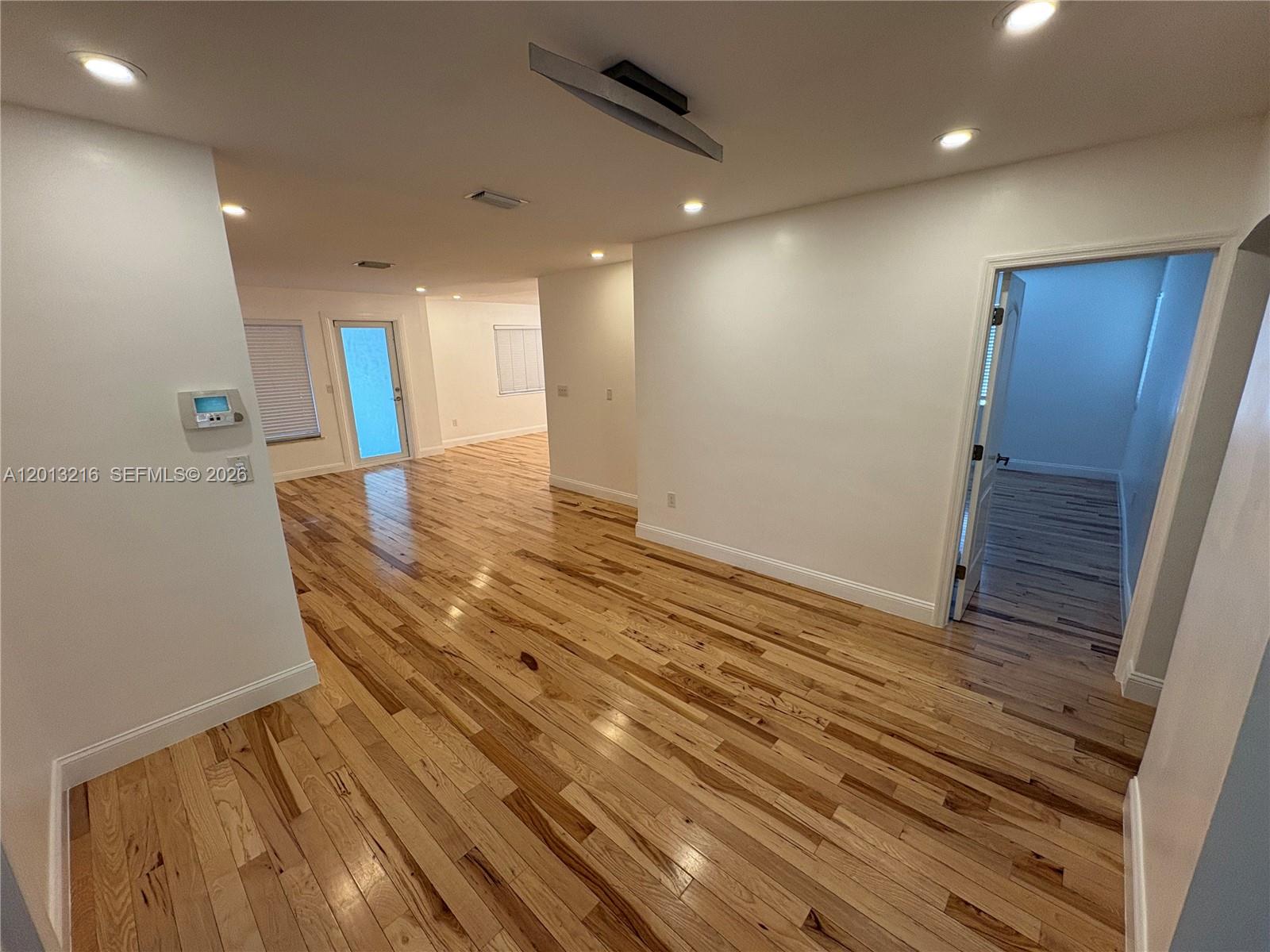 250 Southwest 19th Road Miami, FL 33129 - Photo 7 of 22 a view of an empty room with wooden floor and a window