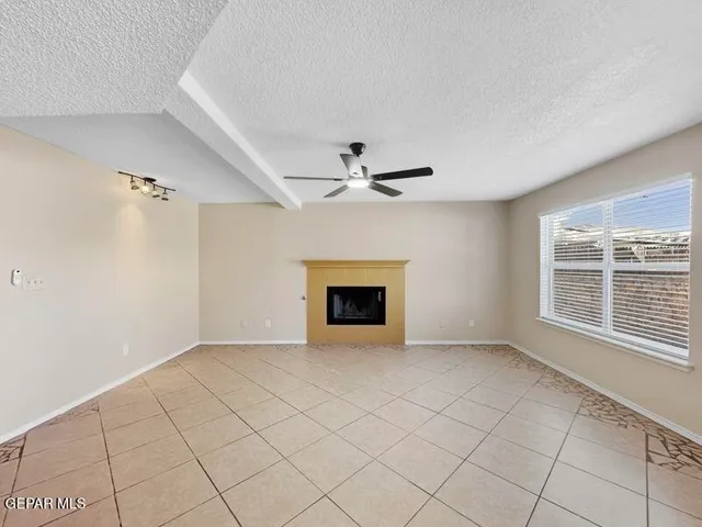 a view of an empty room with a fireplace and a window
