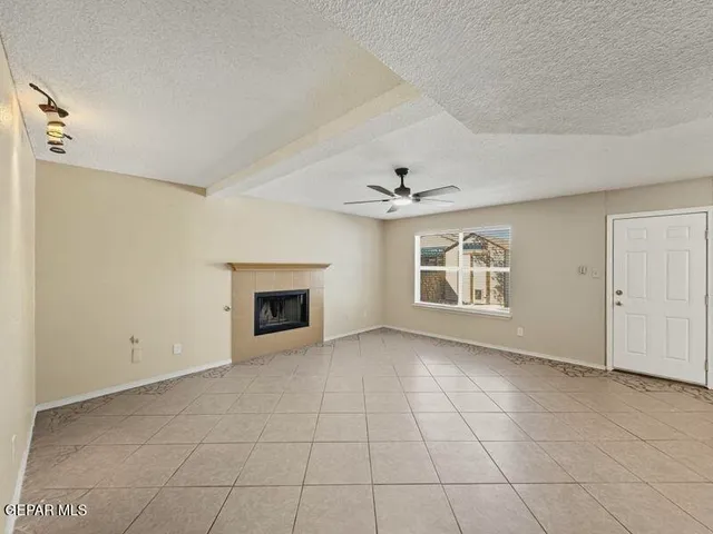 an empty room with windows and fireplace